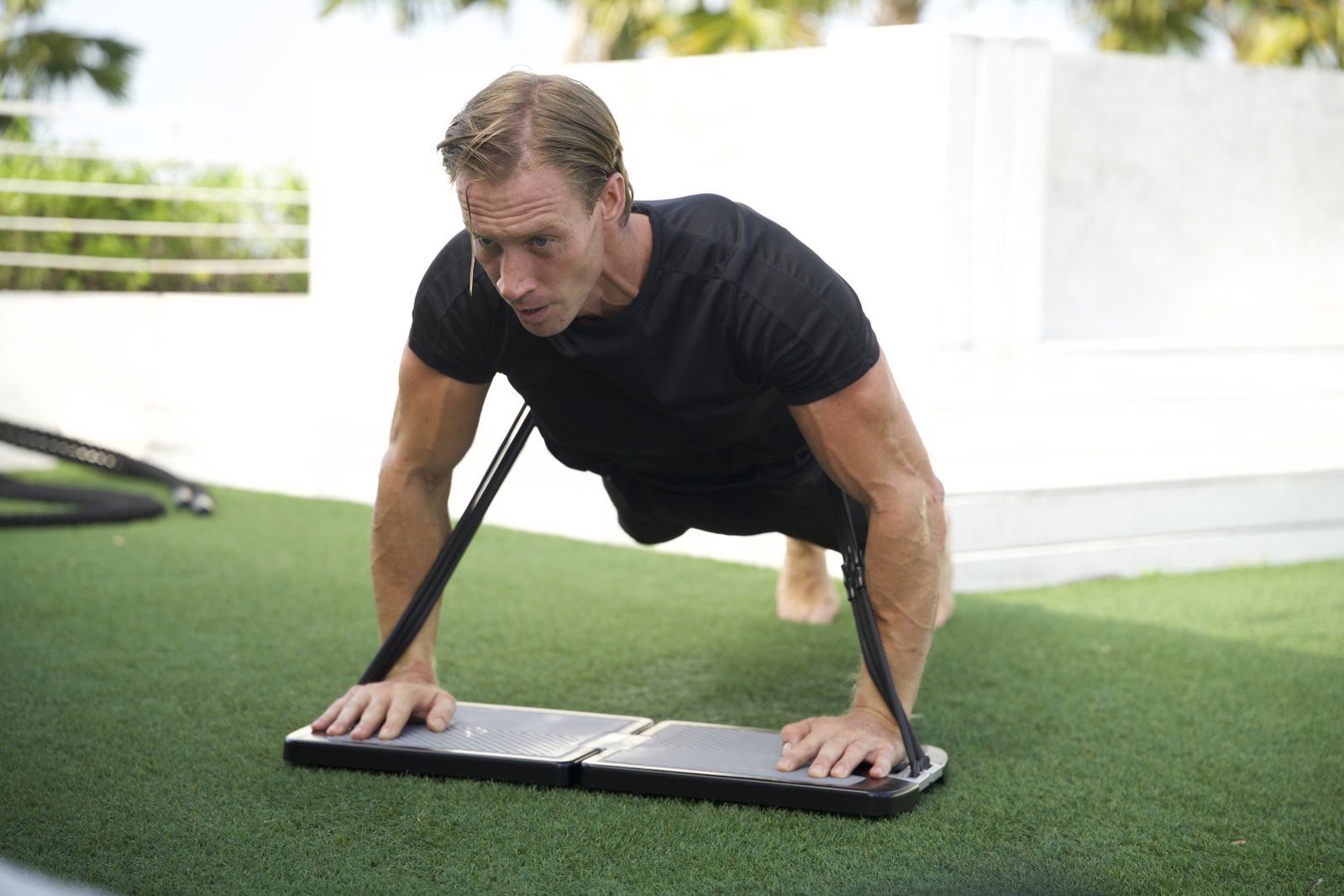 Weighted push-up with bands running over the back and anchored in the EVO Base
